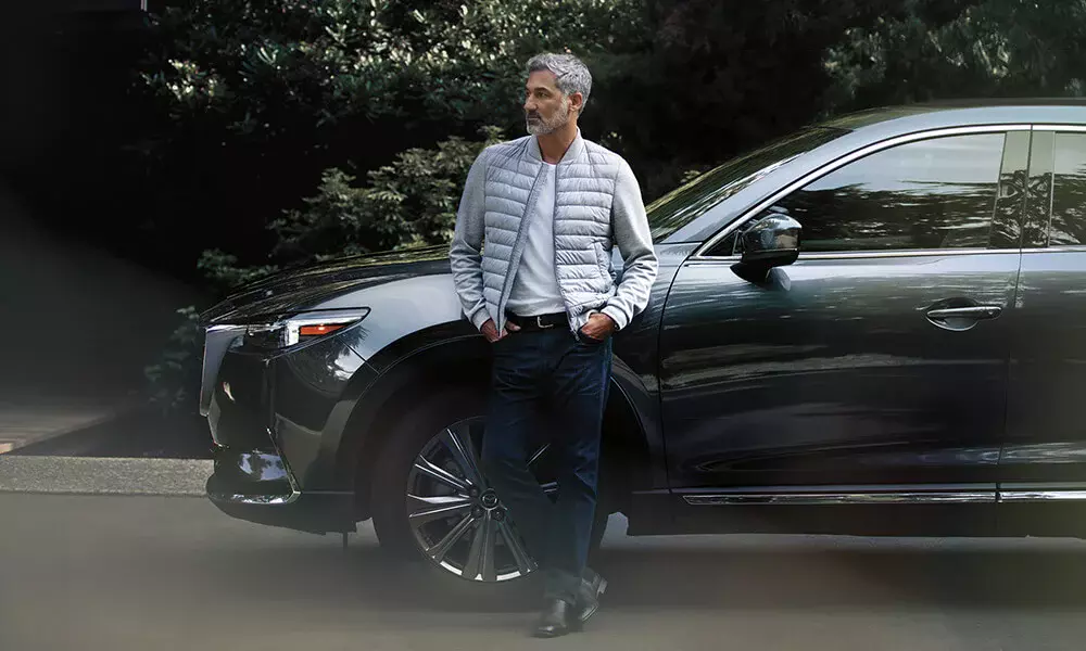 Mazda owner leaning against his SUV